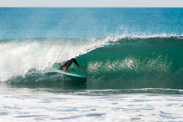 Man surfing after the wave, inside the tube of the wave break.