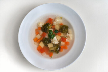 Healthy eating. Dietary food. Dietary vegetable soup with a broccoli and cauliflower in a plate isolated on a white background