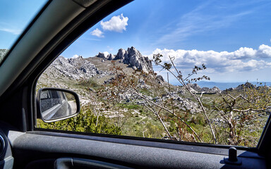 View from a car window on the rocks and sparse vegetation in the Velebit mountains, Croatia, during...