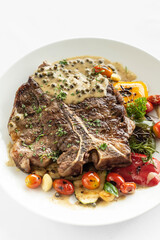 grilled t-bone steak with peppercorn sauce and vegetables