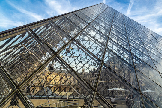 Paris, France - March 29, 2017: View of famous Louvre Museum with Louvre Pyramid at evening. Louvre Museum is one of the largest and most visited museums worldwide