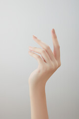 A front view of hand posing in white background for cosmetic advertising 