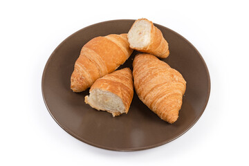 Whole and halves of puff pastry croissants on brown dish