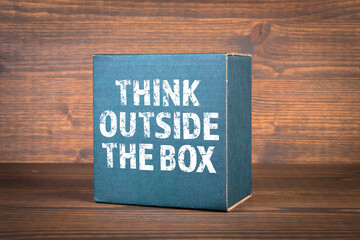 Think outside the box. Cardboard box on a wooden background