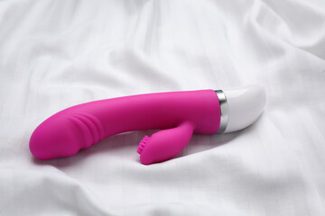 Pink vibrator on white fabric. Sex toy - obrazy, fototapety, plakaty
