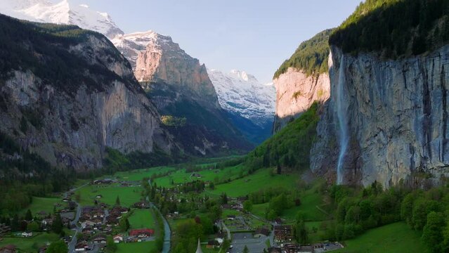 Lauterbrinnen valley in Switzerland, famous Swiss alpine village landscape with Staubbach waterfall at sunrise, pictiresque aerial view of Lauterbrunnen valley