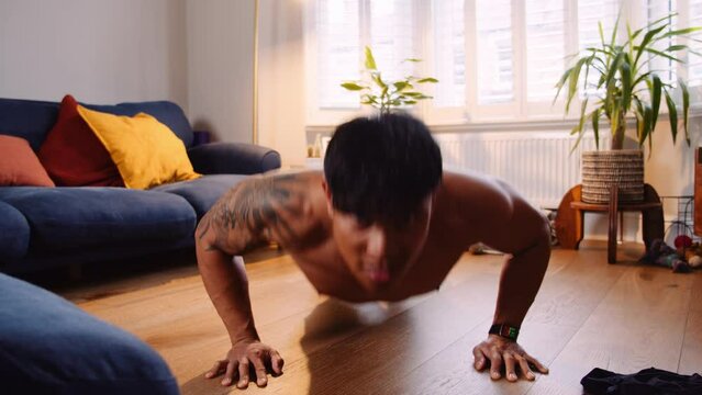 Asian man doing pushup at home