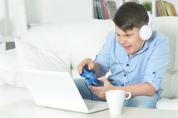 boy playing computer game with laptop