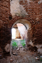Arch in a red brick wall. Ruined wall of an antique Russian church.