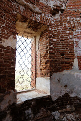 Window in a red brick wall. Ruined wall of an antique Russian church.