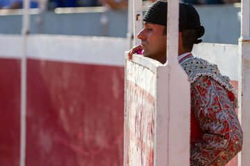 close up of a concentrated bullfighter watches the bullfight from the sidelines