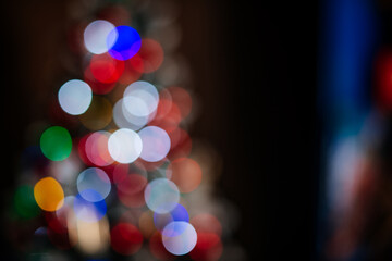 Christmas tree in lights on red background- soft focus and bokeh