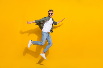 Fototapeta na wymiar Full length body size view of attractive cheerful comic guy jumping fooling isolated over bright yellow color background