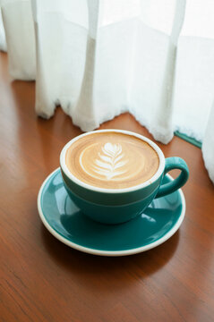 Top View Of Hot Coffee Latte And Heart Shaped Latte Art In A Green Mug On Wooden Table