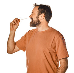 bearded man performing antigen test with unpleasant expression. on white isolated background for...