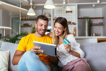 Happy young couple shopping online with digital tablet and credit card at home