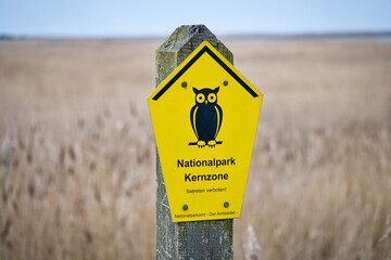 Sign National Park Core Zone on the Baltic Sea. Symbol owl with yellow background.