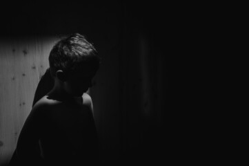 Black and white portrait of sad anonymous little boy