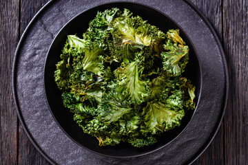 black bowl with kale chips on the table - obrazy, fototapety, plakaty