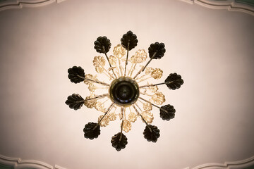 Openwork chandelier under ceiling.