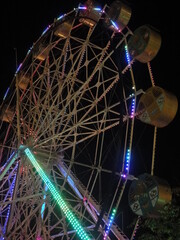 Ferris wheel that emits colorful lights at night