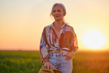 portrait of a middle-aged woman in the wheat field at sunset