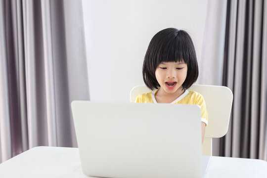 little asian girl student study online using laptop computer at home