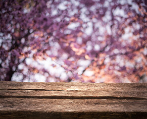 Empty old brown wooden table in front of art abstract bokeh background of Spring trees with bokeh for your display or montage