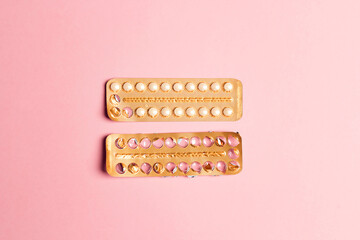Female oral contraceptive pills empty and full blister on a pink background. - obrazy, fototapety, plakaty