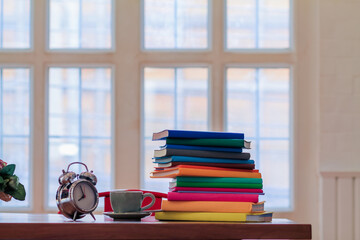 Many colorful textbooks are placed on  desk in study room as they are prepared for students to...