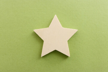 Top view image of wooden star over textured green background