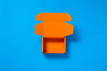 Empty co;or cardboard box on blue background