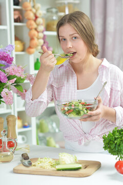 teen girl preparing fresh salad
