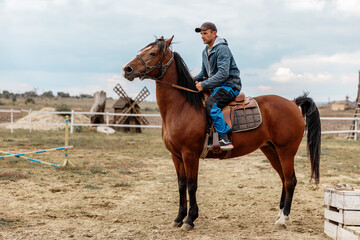 Portrait of a 30-40 years old man farmer riding his horse .