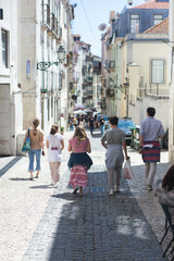 Obraz premium A family walking down a street in Lisbon, Portugal