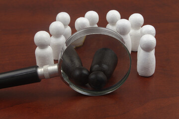 Crime, racism and discrimination concept. Two black people figure laying under magnifying glass...