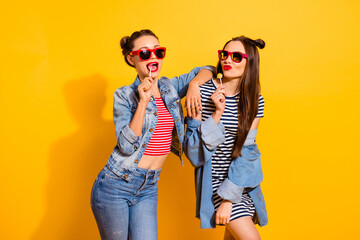 Photo of two ladies having fun lick candies wear denim clothes isolated on vibrant color background