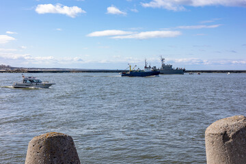 A warship and boats sail through the sea bay in Baltiysk, Kalinigrad region, Russia, near the Baltic sea.
