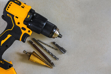 Cordless Hammer Drill/Driver with Drill bits on Cement board background