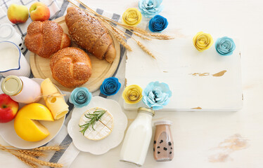 Fototapeta na wymiar top view photo of dairy products over white wooden background. Symbols of jewish holiday - Shavuot