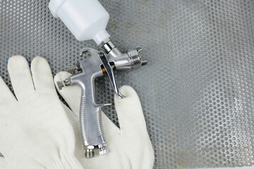 paint spray gun at work at the workplace in the workshop.