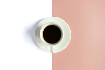 Top view of Coffee in cup with foam on a pink and white background.