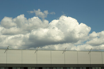 Warehouse and sky. Grey building. Clouds over the warehouse.