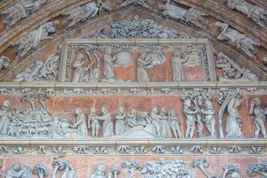 Close-up of the tympanon above main gate of Ulm cathedral. At the top of the historical ornament god is creating plant earth.