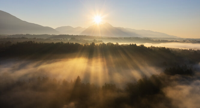 Sunrise over the foggy valley. Beautiful shiny mist. © gljivec