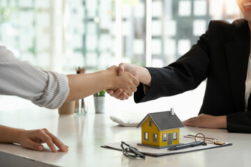 Real estate broker and customer shaking hands after signing a contract: real estate, home loan and...