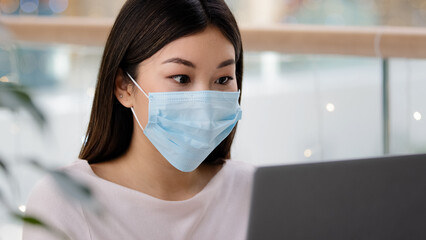 Portrait asian successful girl in medical protective mask business woman looking laptop receives...