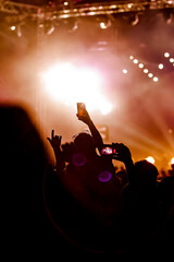 Hand with a smartphone records live music festival, Taking photo of concert stage, live concert,...