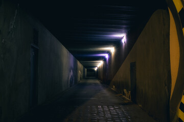 Naklejka na ściany i meble underground path road dangerous way at night with electricity lamps and wall blue and yellow colors, back street criminal district, unfocused concept of photography