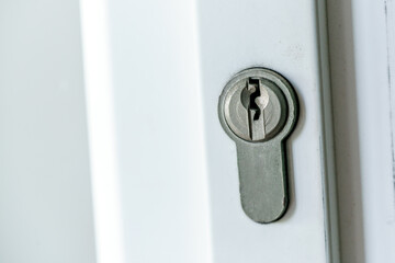 Door lock on a white door. Keyhole close-up. Home security, property protection